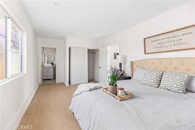 bedroom featuring a closet, light hardwood / wood-style flooring, and multiple windows