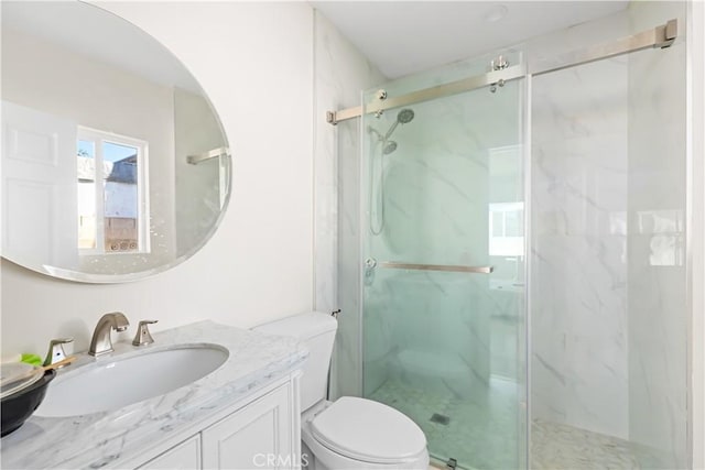 bathroom with vanity, a shower with shower door, and toilet