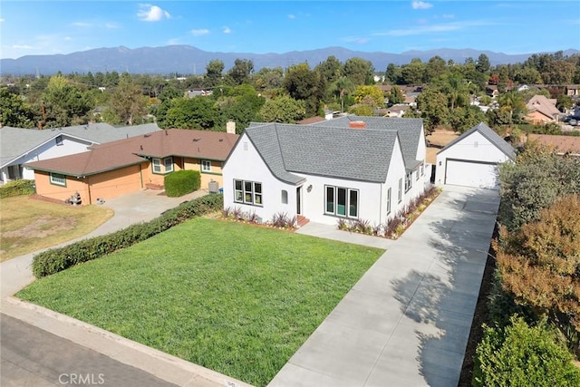 view of front facade with a mountain view, a garage, and a front lawn