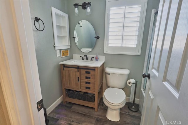 bathroom featuring vanity, wood-type flooring, and toilet