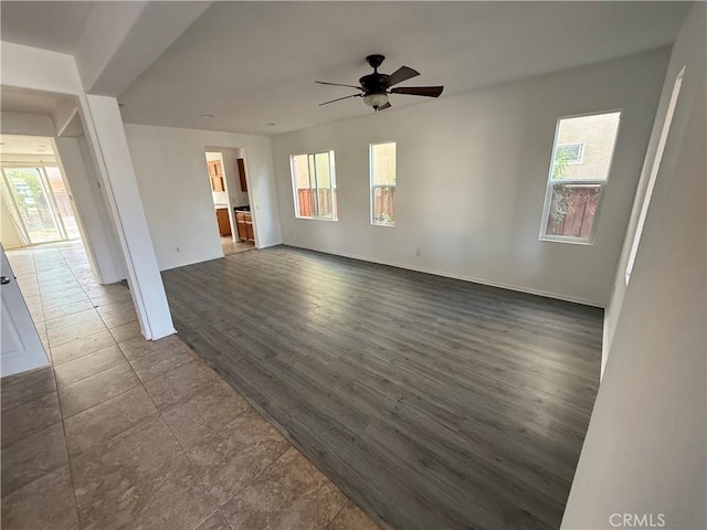 unfurnished living room featuring dark hardwood / wood-style flooring, ceiling fan, and plenty of natural light