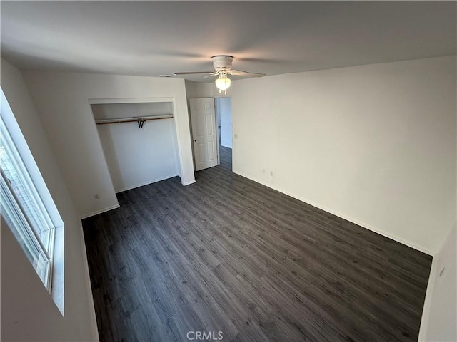 unfurnished bedroom featuring a closet, dark hardwood / wood-style floors, and ceiling fan