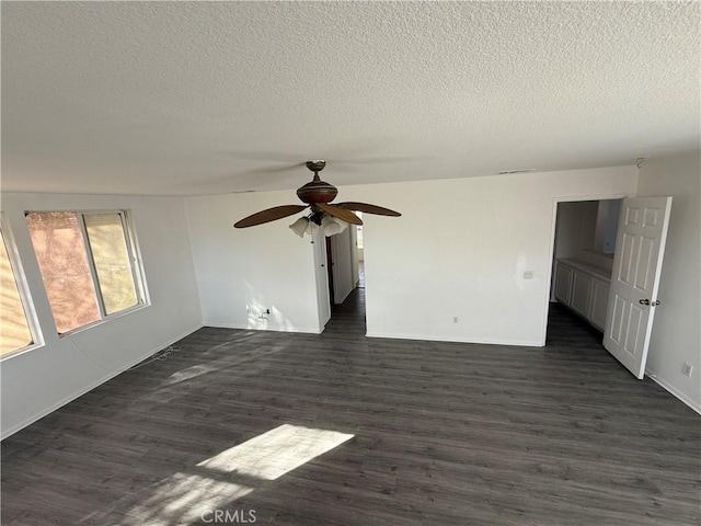 empty room with a textured ceiling, dark hardwood / wood-style flooring, and ceiling fan