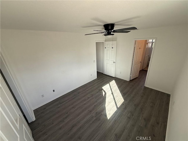 empty room featuring ceiling fan and dark hardwood / wood-style flooring