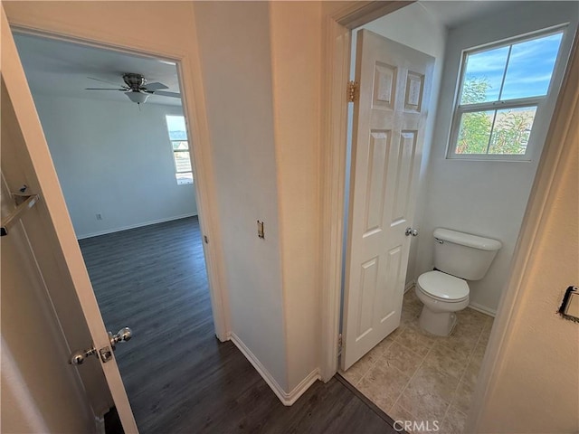 bathroom with hardwood / wood-style floors, toilet, and ceiling fan