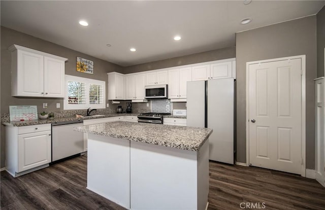 kitchen featuring a center island, white cabinetry, stainless steel appliances, and dark wood-type flooring