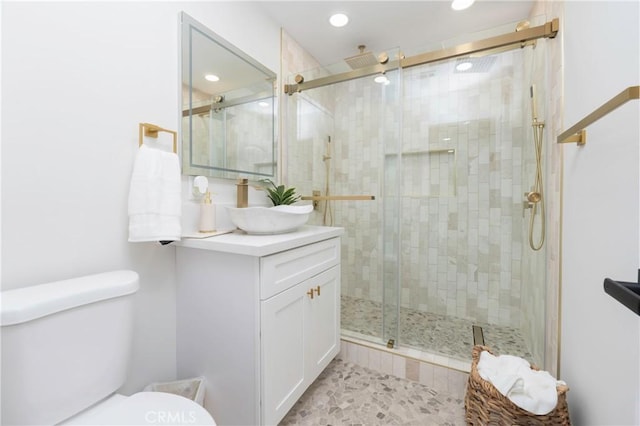 bathroom with tile patterned floors, vanity, toilet, and a shower with shower door