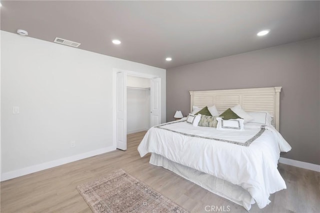 bedroom with light hardwood / wood-style floors, a spacious closet, and a closet