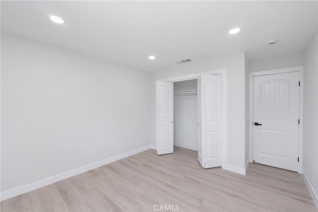 unfurnished bedroom featuring light wood-type flooring and a closet