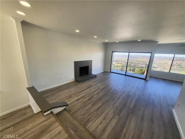 unfurnished living room with dark wood-type flooring and crown molding