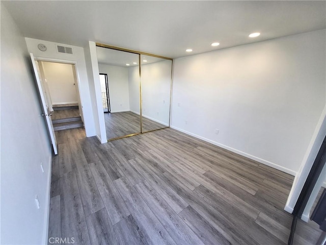 unfurnished bedroom featuring hardwood / wood-style floors and a closet