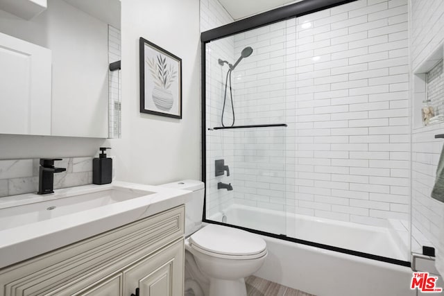 full bathroom with vanity, toilet, and bath / shower combo with glass door