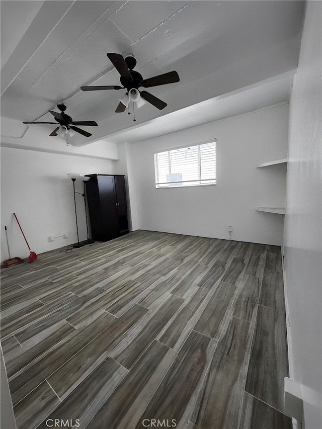 unfurnished living room with a ceiling fan and wood finished floors