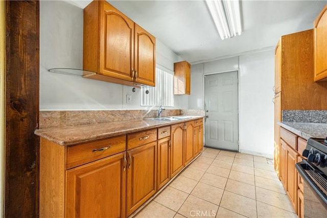 kitchen with light stone countertops, sink, black range, and light tile patterned floors