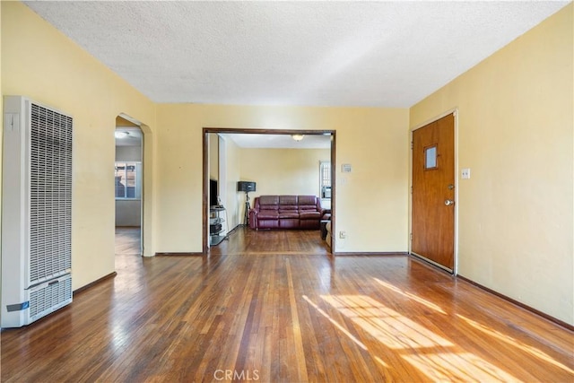 unfurnished room with dark hardwood / wood-style floors and a textured ceiling