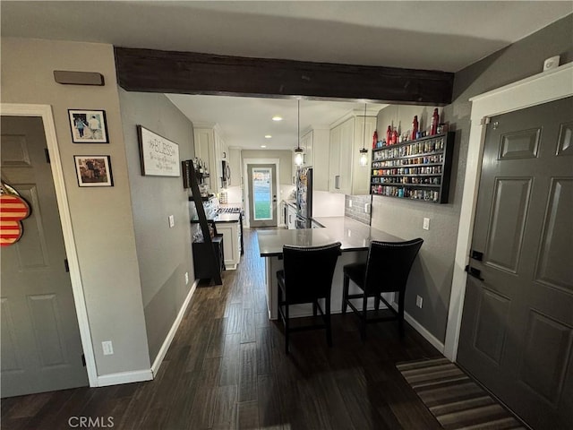 dining space with beamed ceiling and dark wood-type flooring