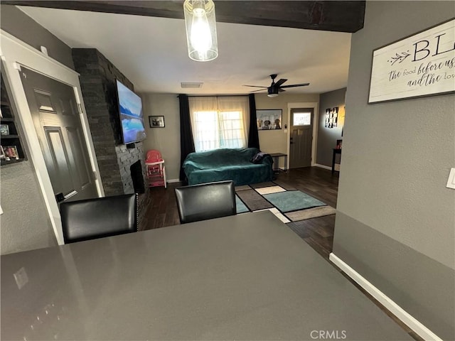 living room featuring ceiling fan and dark hardwood / wood-style flooring