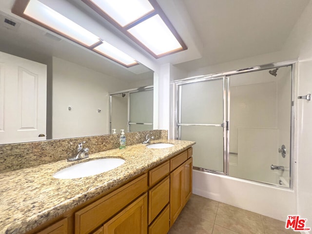 bathroom with shower / bath combination with glass door, tile patterned flooring, and vanity