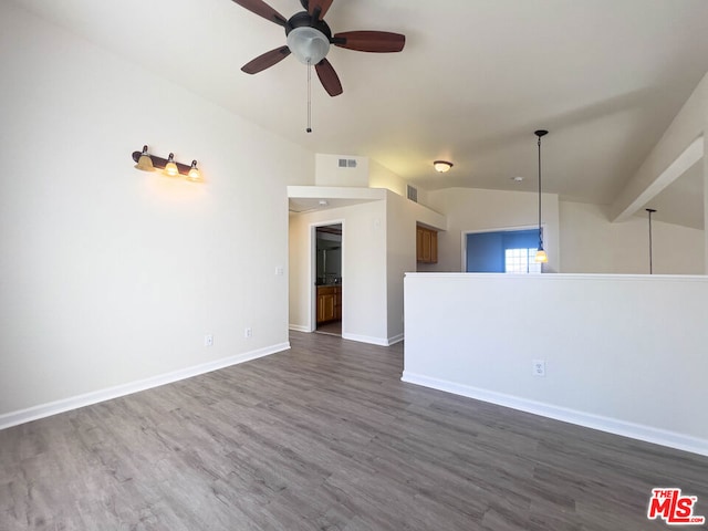 unfurnished room with dark hardwood / wood-style flooring, vaulted ceiling, and ceiling fan