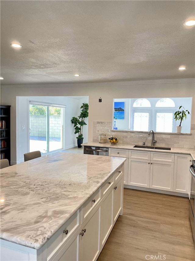 kitchen featuring white cabinetry, sink, a wealth of natural light, and light hardwood / wood-style flooring