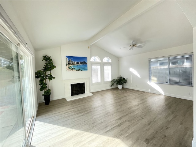 unfurnished living room with vaulted ceiling with beams, ceiling fan, a fireplace, and hardwood / wood-style flooring