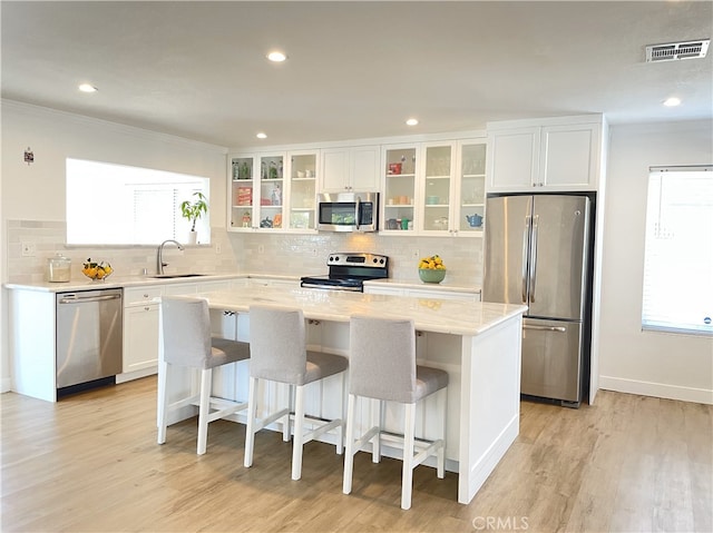 kitchen featuring sink, a center island, a healthy amount of sunlight, and appliances with stainless steel finishes