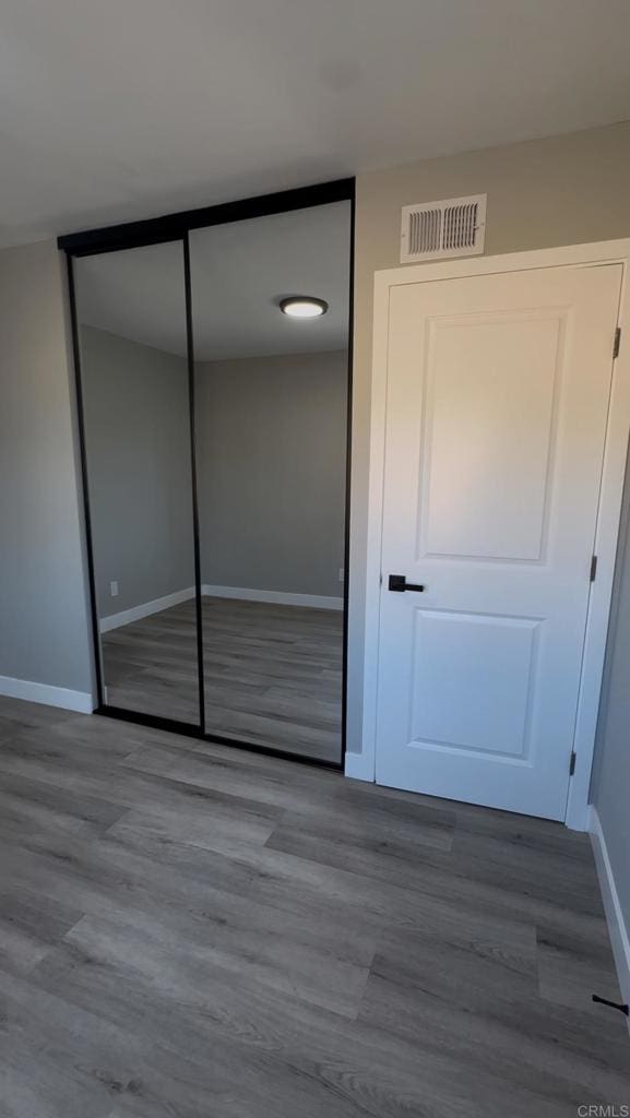 unfurnished bedroom with hardwood / wood-style floors and a closet