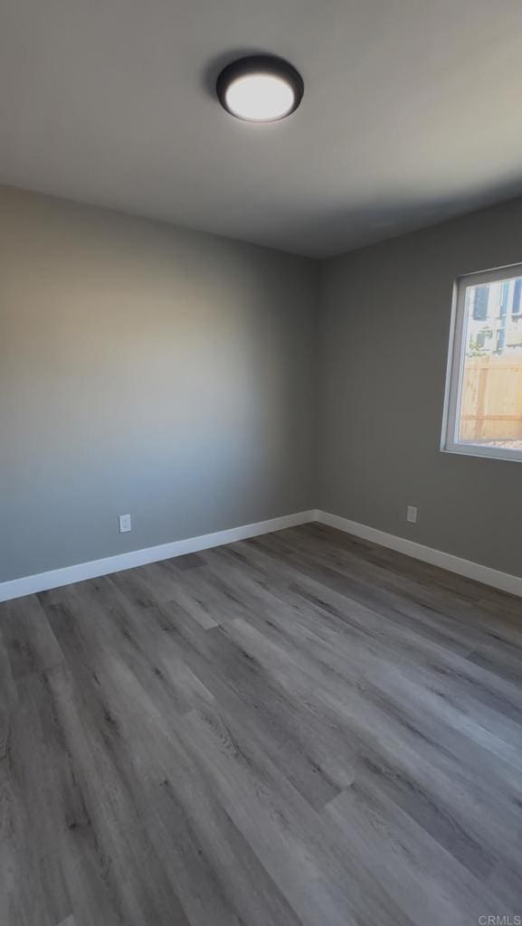 unfurnished room with wood-type flooring