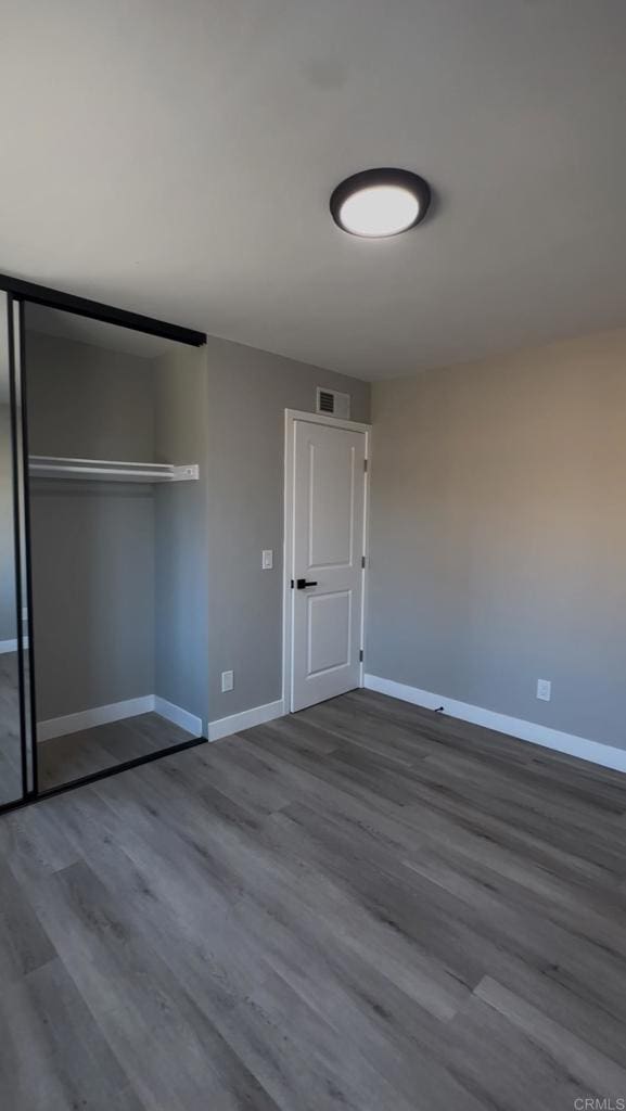 unfurnished bedroom featuring hardwood / wood-style flooring and a closet