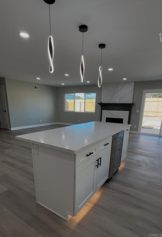 kitchen featuring white cabinets, a healthy amount of sunlight, dark hardwood / wood-style flooring, and hanging light fixtures