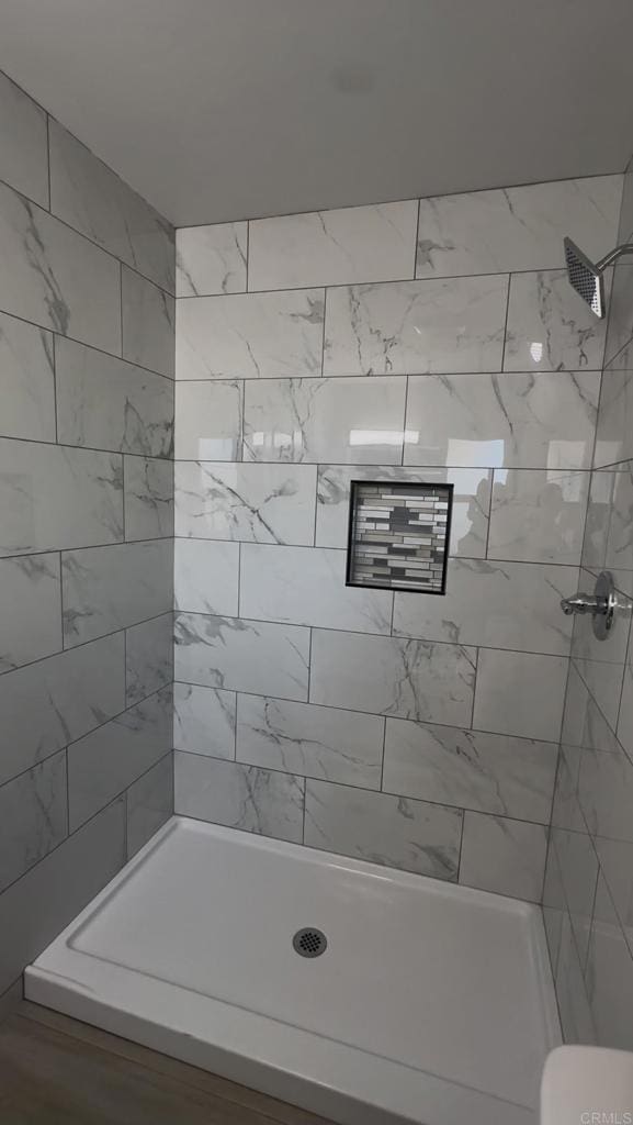 bathroom with toilet and tiled shower