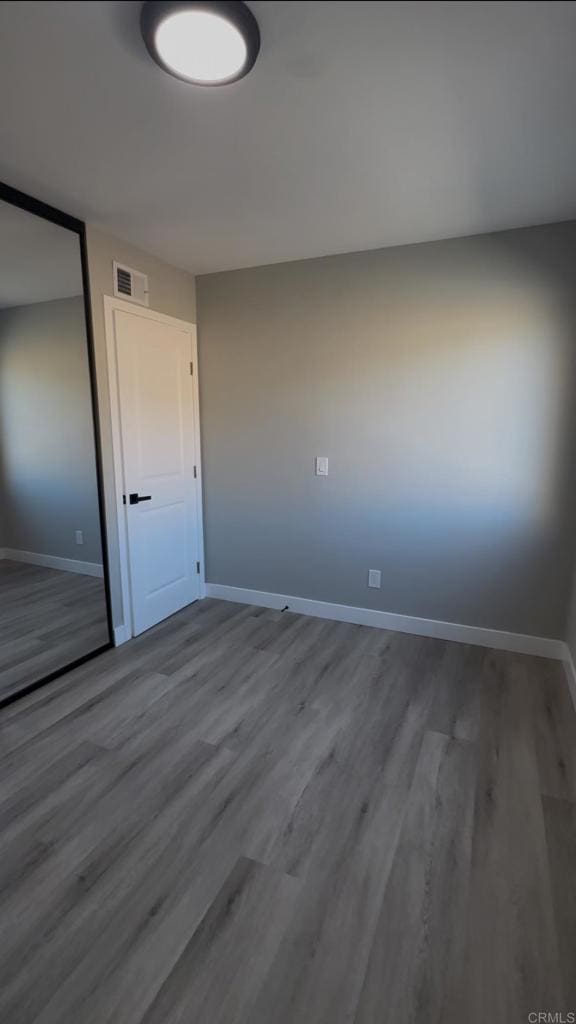 spare room with wood-type flooring