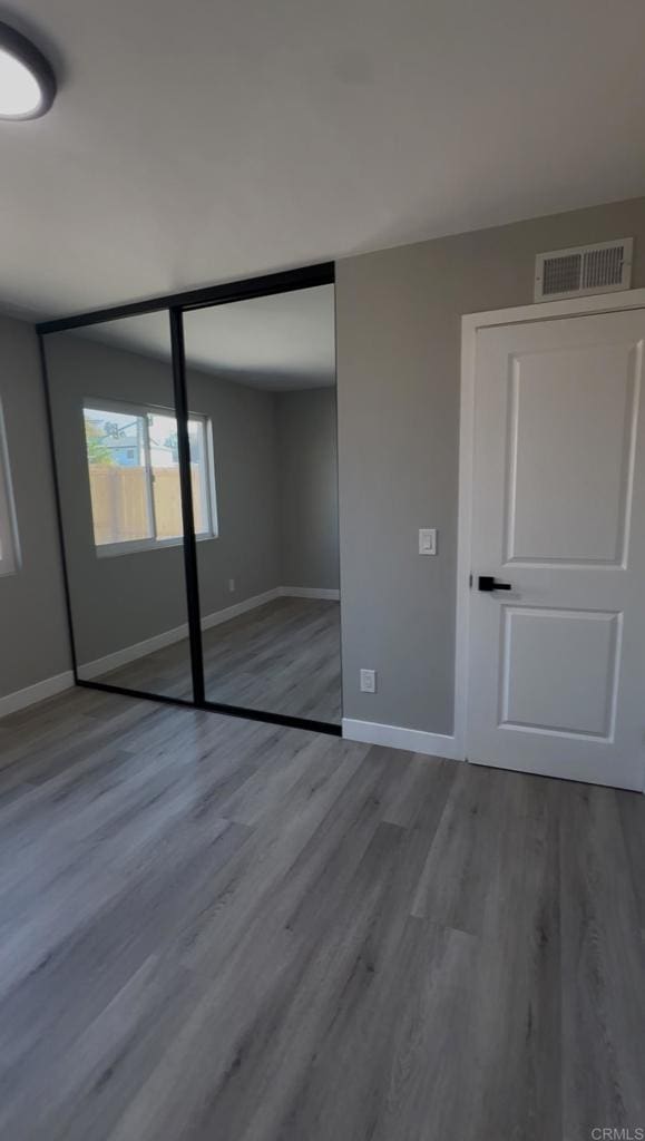 unfurnished bedroom with hardwood / wood-style floors and a closet