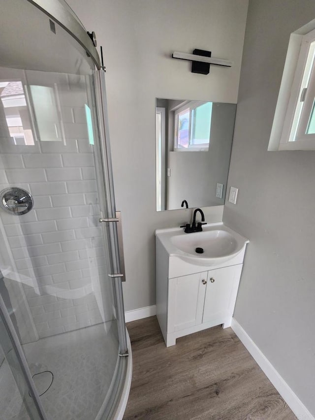 bathroom featuring hardwood / wood-style floors, vanity, and a shower with door