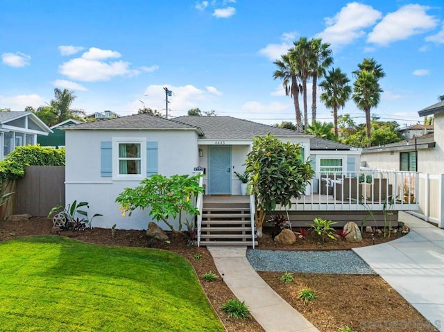 bungalow-style house featuring a deck and a front yard