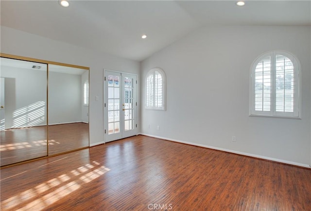 empty room with dark hardwood / wood-style flooring, a wealth of natural light, and french doors