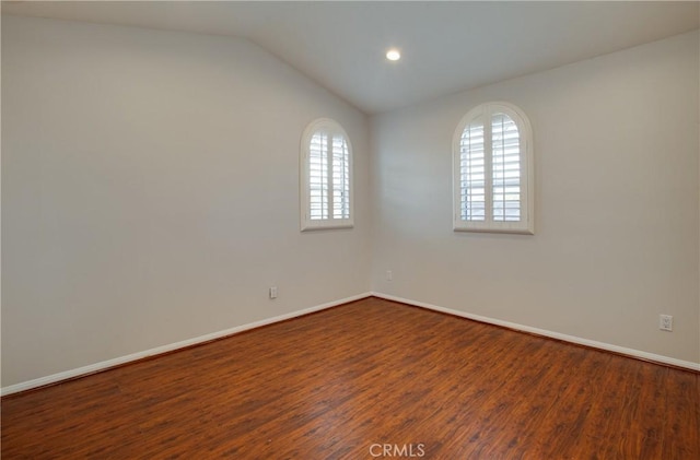 empty room featuring a wealth of natural light, wood-type flooring, and lofted ceiling