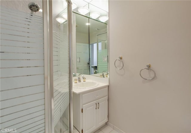 bathroom featuring tile patterned floors, vanity, and a tile shower