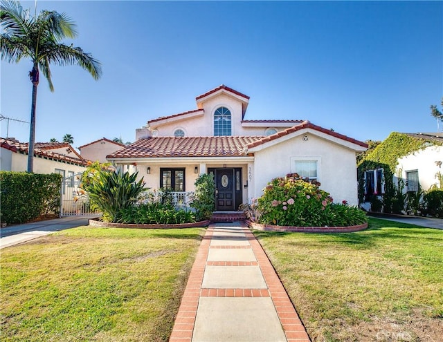 mediterranean / spanish-style home with a front lawn