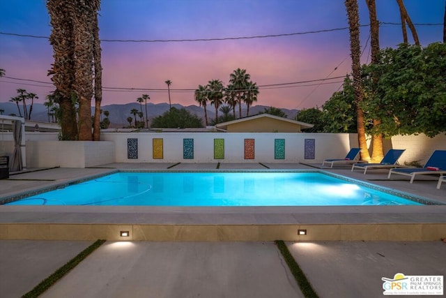 pool at dusk with a patio