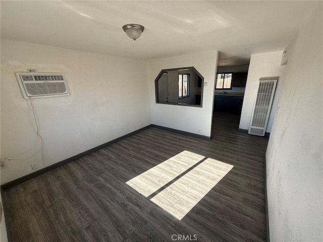 unfurnished room with dark hardwood / wood-style floors and a wall mounted AC