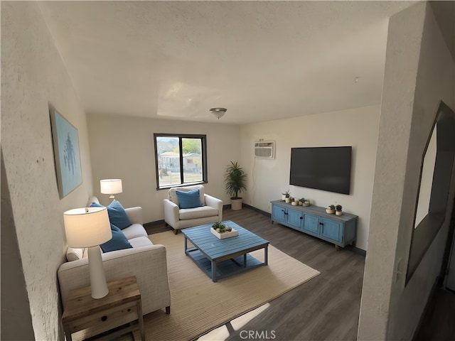 living room with an AC wall unit and dark hardwood / wood-style flooring