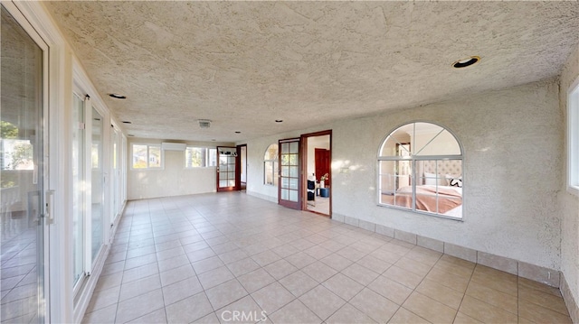 empty room with light tile patterned floors and french doors