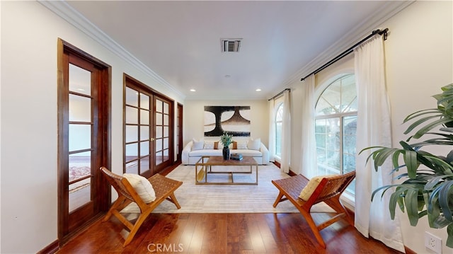 sitting room with crown molding, hardwood / wood-style floors, and french doors