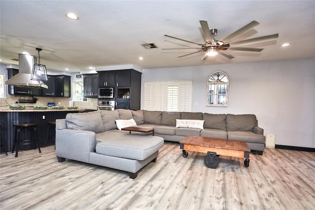 living room featuring light hardwood / wood-style floors and ceiling fan