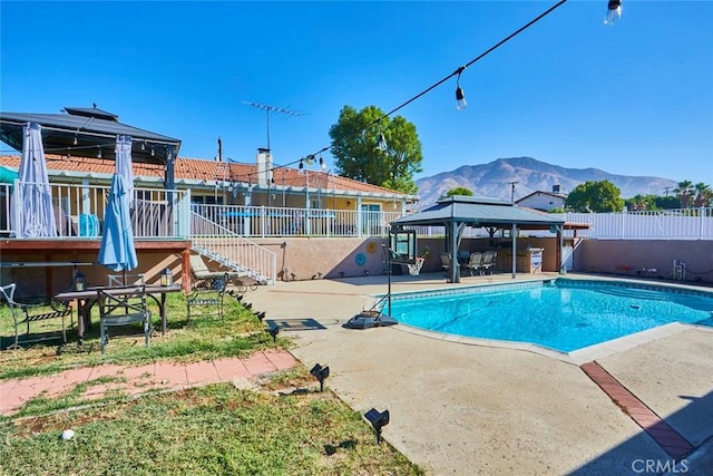 view of swimming pool with a gazebo, a mountain view, and a patio area