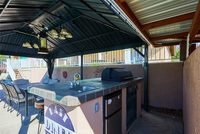 view of patio / terrace featuring a gazebo, an outdoor kitchen, a wet bar, and grilling area