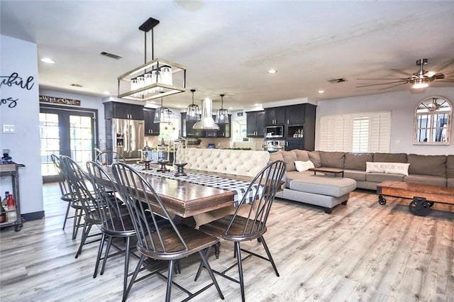 dining area featuring ceiling fan, french doors, and light hardwood / wood-style flooring