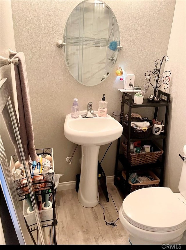 bathroom featuring hardwood / wood-style flooring and toilet