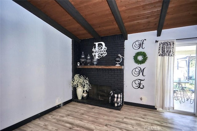 unfurnished living room with a fireplace, wood-type flooring, lofted ceiling with beams, and wooden ceiling